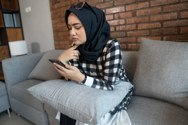 Unatkozó nő otthon használja a mobilját — Stock Fotó