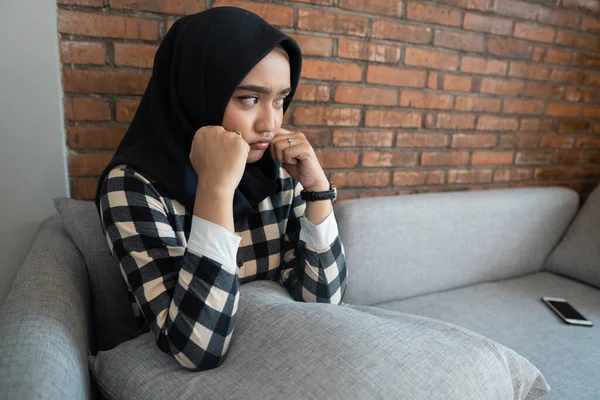 Gelangweilte Muslimin sitzt auf einer Couch — Stockfoto