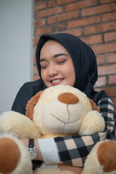 muslim woman hug her stuffed animal