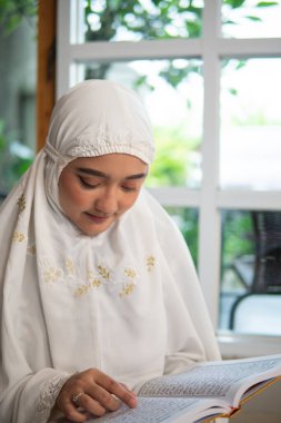 Müslüman kadın Kuran okuyup öğreniyor.
