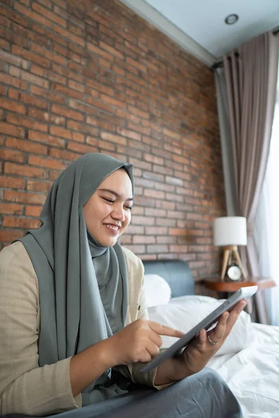 Musulmán asiático mujer usando tableta sentado en la cama — Foto de Stock