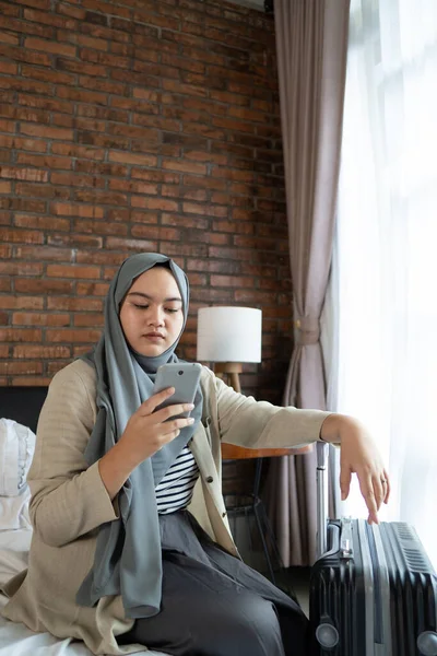 Musulmanes mujeres asiáticas mirando horarios de entradas usando smartphone — Foto de Stock