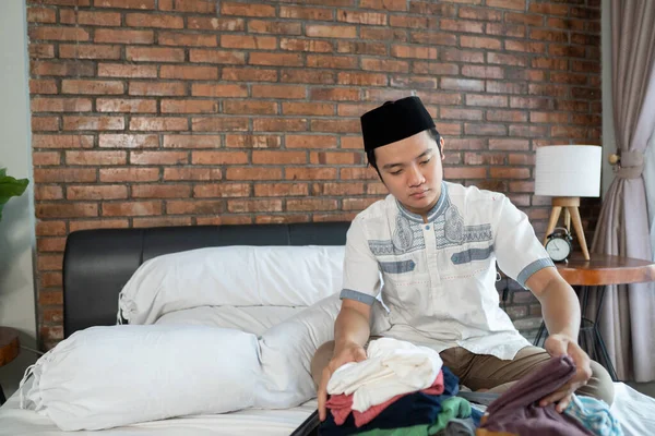 Muslim Asia laki-laki mempersiapkan dan packing pakaian — Stok Foto