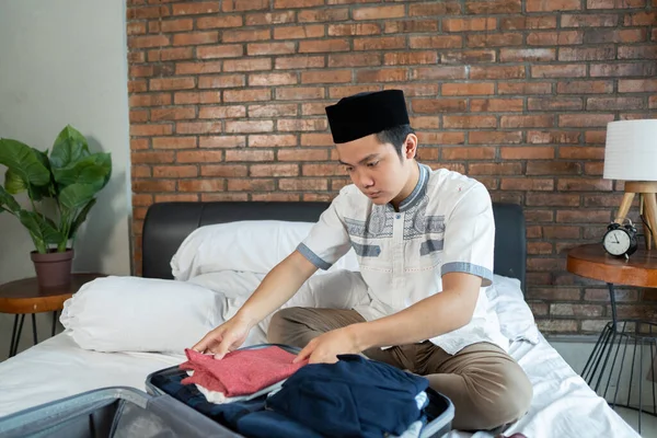 Muçulmano ásia masculino preparação e embalagem de roupas — Fotografia de Stock