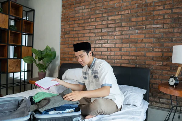 Muslim asian male holding paper checklist for luggage — Stock Photo, Image