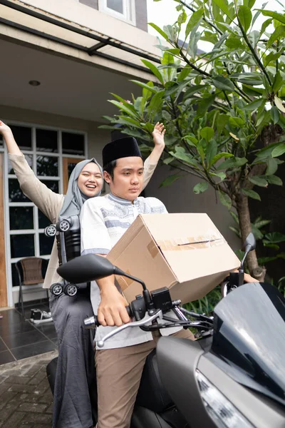 Asiático casais muçulmanos com moto mudik carregando lotes de itens — Fotografia de Stock