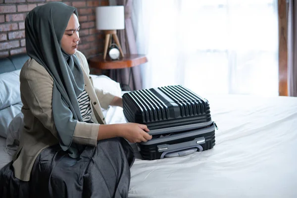 Mulher de véu muçulmano que embala algumas roupas — Fotografia de Stock