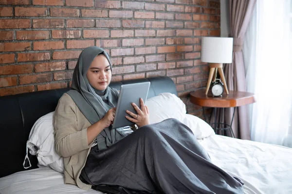 Muszlim fiatal nő használja tabletta látszó foglalási jegy — Stock Fotó