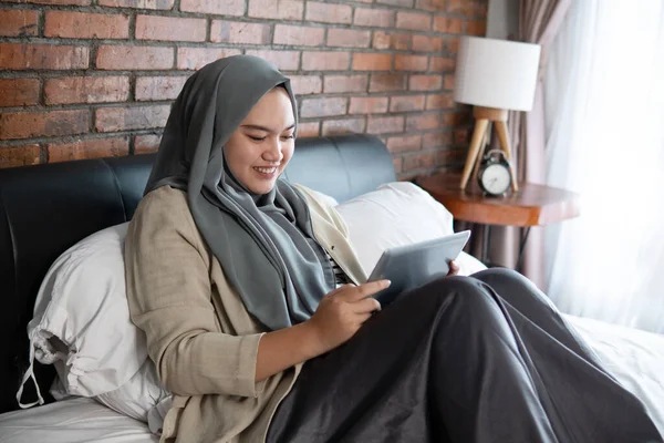 Muslim mladá žena pomocí tabletu vypadající rezervace vstupenka — Stock fotografie