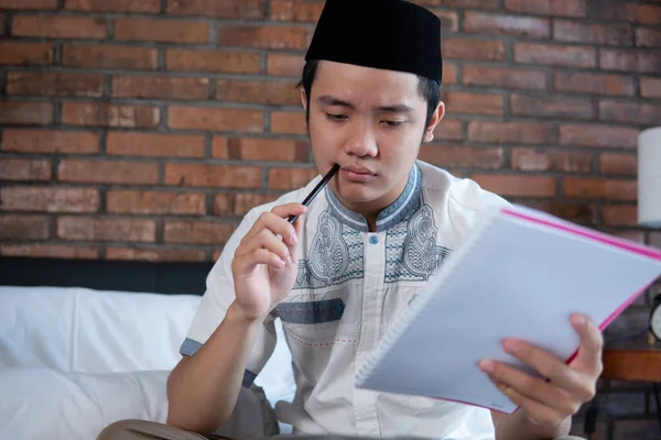 Muslim asiatische Mann hält Papier Checkliste für Gepäck — Stockfoto