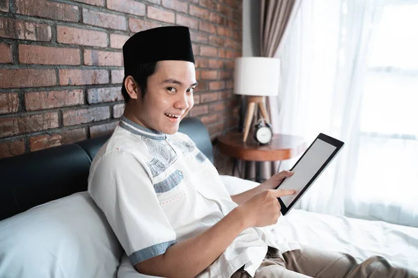 Macho muçulmano sorrindo quando usar tablets porque obter um bilhete de desconto — Fotografia de Stock