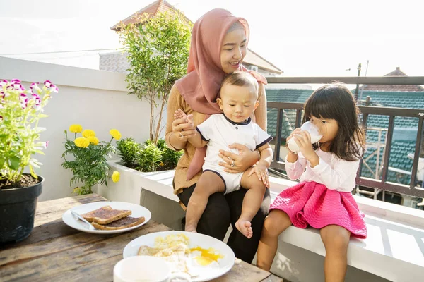 Muslimská žena a děti snídaně — Stock fotografie