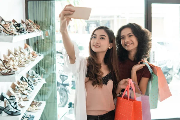 Két nő barátok csinál egy szelfi vásárlás közben — Stock Fotó