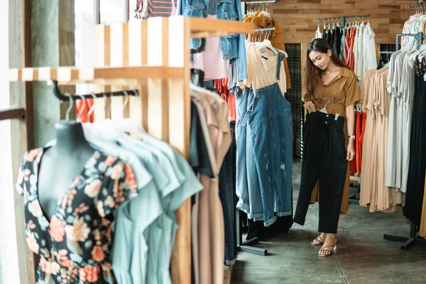 Vrouw op zoek naar een aantal kleren in de modewinkel — Stockfoto