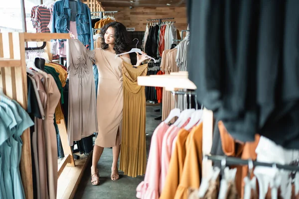 Donna guardando alcuni vestiti nel negozio di moda — Foto Stock