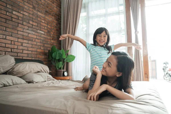 Sibling sister play together on the bed — Stock Photo, Image