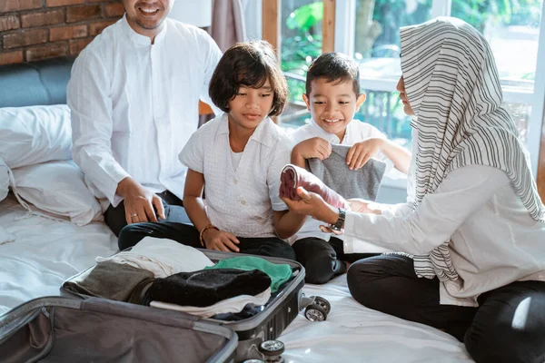 Família muçulmana prepara roupas para transportar quando mudik — Fotografia de Stock