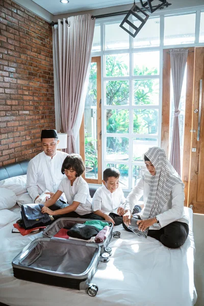 Aziatische familie bereiden kleding en zet in koffer — Stockfoto