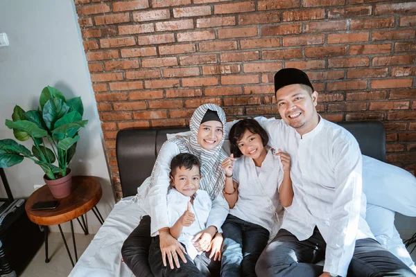 Мусульманские семьи с детьми отдыхают и шутят на кровати — стоковое фото