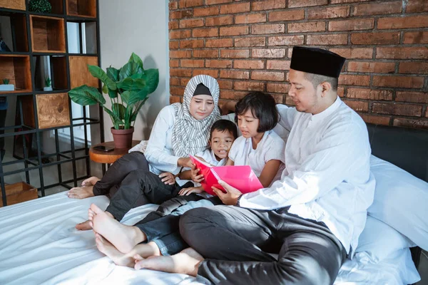 İki çocuklu bir aile birlikte kitap okuyor. — Stok fotoğraf