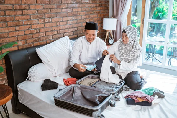 Pasangan muslim mempersiapkan pakaian di atas koper — Stok Foto