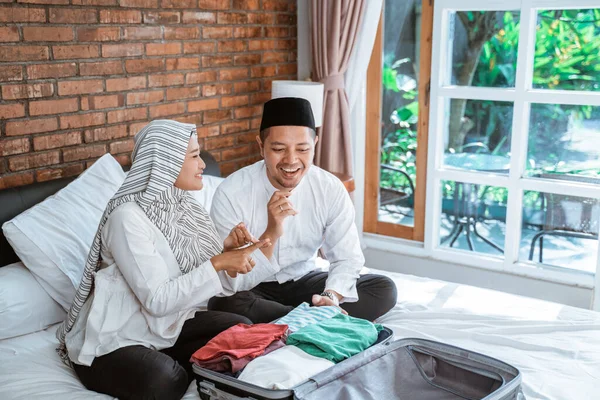 Pasangan muslim mempersiapkan pakaian di atas koper — Stok Foto