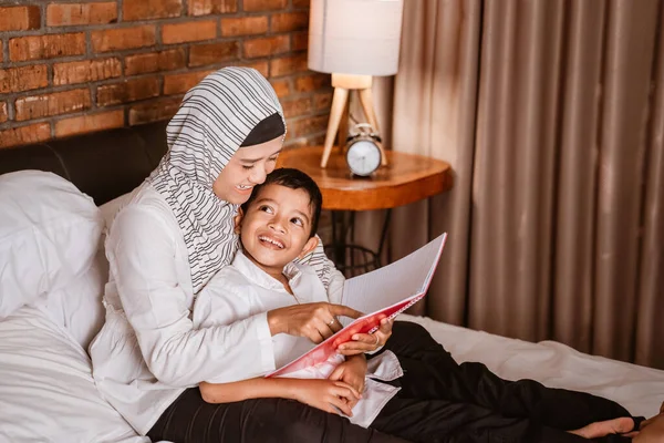 Ibu muslim membaca buku dengan anaknya — Stok Foto