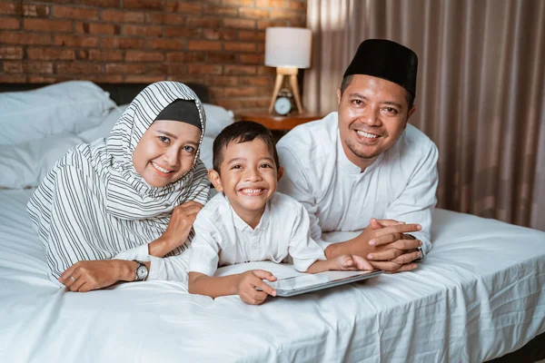 Familia musulmana usando tabletas en la cama — Foto de Stock