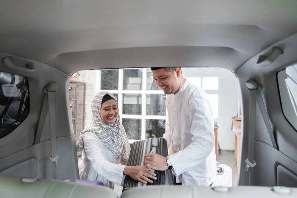 Muslim ζευγάρι συσκευασίας βαλίτσα στο αυτοκίνητο — Φωτογραφία Αρχείου