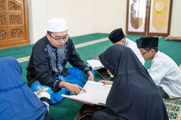 Научить мусульманского ребенка читать куран — стоковое фото