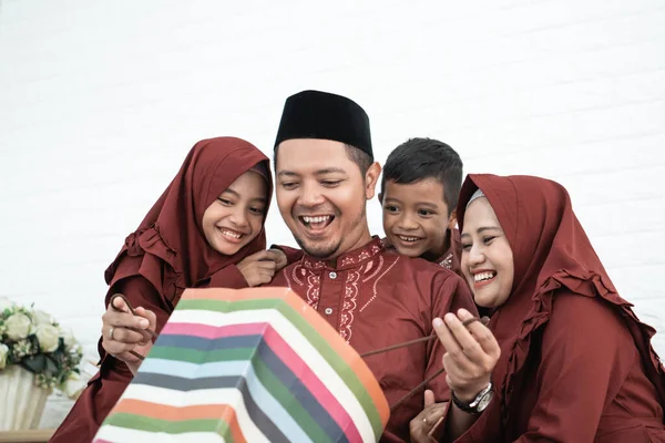 Moslim vader opende een verrassing van papieren zakken — Stockfoto