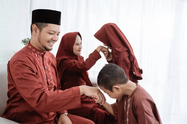 Asiatisk pojke kysser sina fäder hand när firar Happy Eid Ul- — Stockfoto