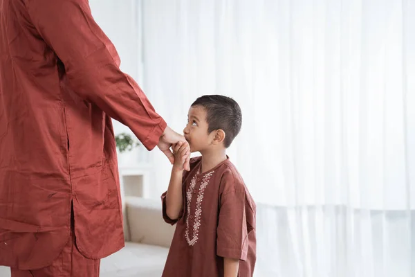 Asiatisk pojke kysser sina fäder hand när firar Happy Eid Ul- — Stockfoto