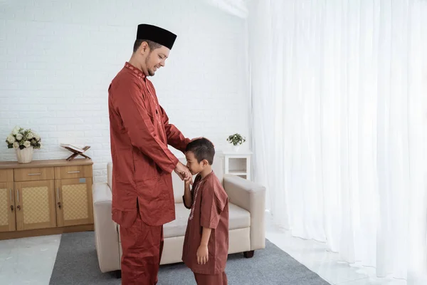 Asiatische Junge küsst seine Väter Hand, wenn Happy Eid Ul feiern- — Stockfoto