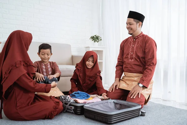 Ázsiai család ruhát készít, és tegye a bőröndbe — Stock Fotó