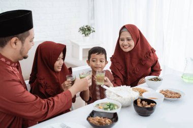 Müslüman aile kahvaltı yaparken tatlı içkinin tadını çıkarıyor.
