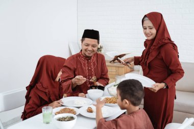Müslüman aile kahvaltıda yemek için oturur.