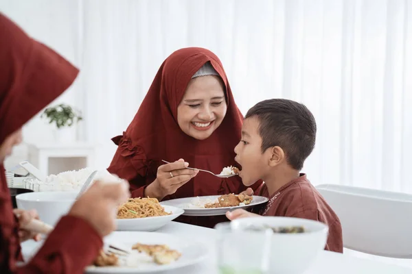 Madre sonrisa al alimentar a su hijo —  Fotos de Stock