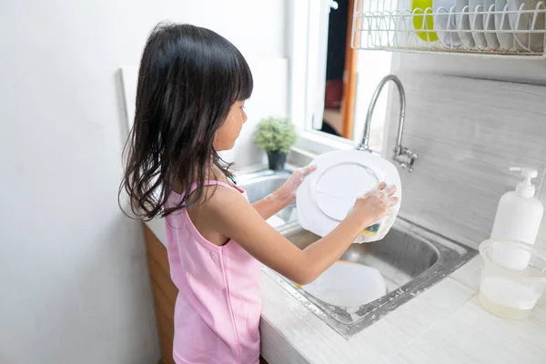 Asiático niña lavar los platos — Foto de Stock