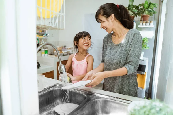 Hija ayudando a su madre en la cocina — Foto de Stock