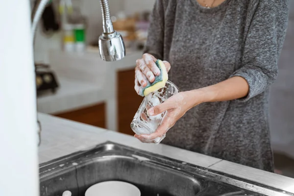 Lava los platos con una esponja en el fregadero — Foto de Stock