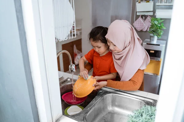 Hija ayudando a lavar platos — Foto de Stock