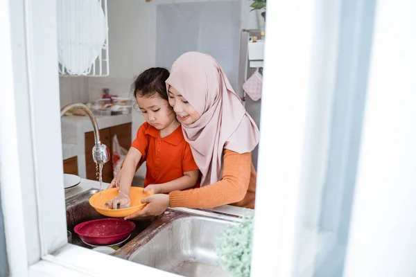 Gadis kecil membantu Ibu-nya di Mencuci Dishes — Stok Foto