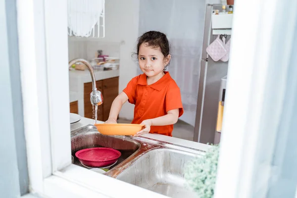 Дитина миє посуд — стокове фото
