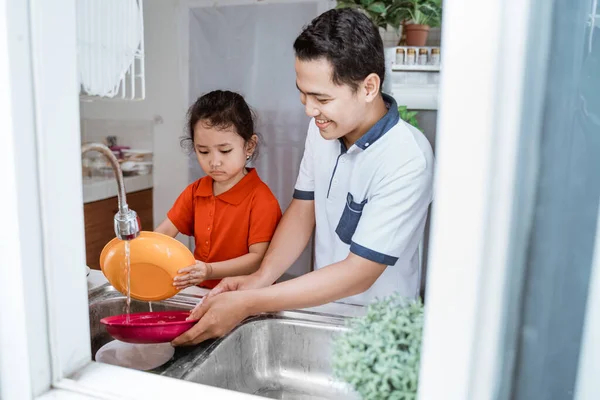 Маленька дівчинка Допоможіть батькові в посуді — стокове фото