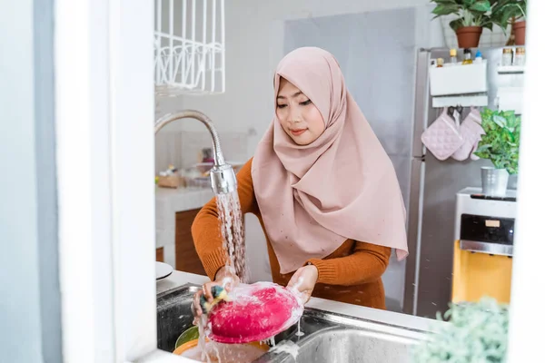 Мусульманская женщина моет посуду — стоковое фото
