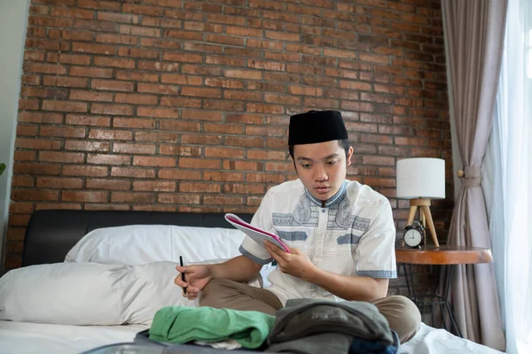 Jovem muçulmano segurando uma lista de verificação de papel para bagagem — Fotografia de Stock