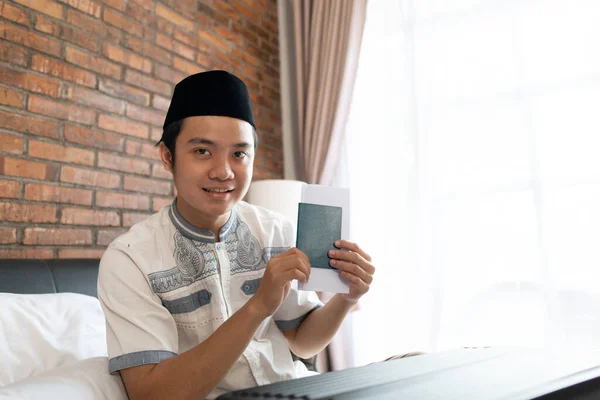 Asyalı Müslüman erkekler pasaport tutarken şapka takarlar — Stok fotoğraf