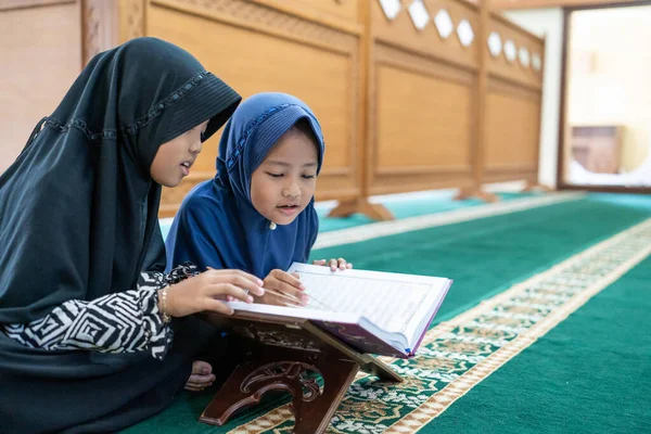 Двое детей читают священный куран — стоковое фото