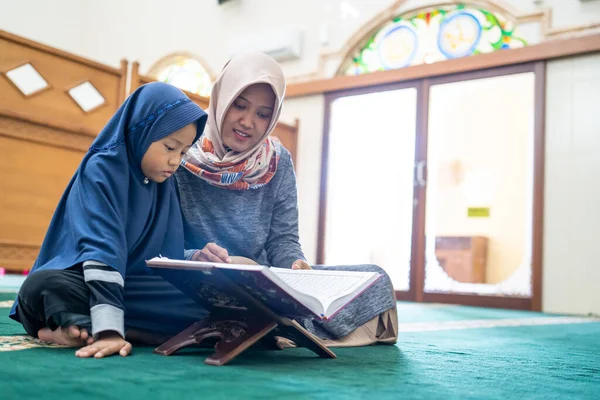 Мусульманка с детьми читает куран вместе — стоковое фото